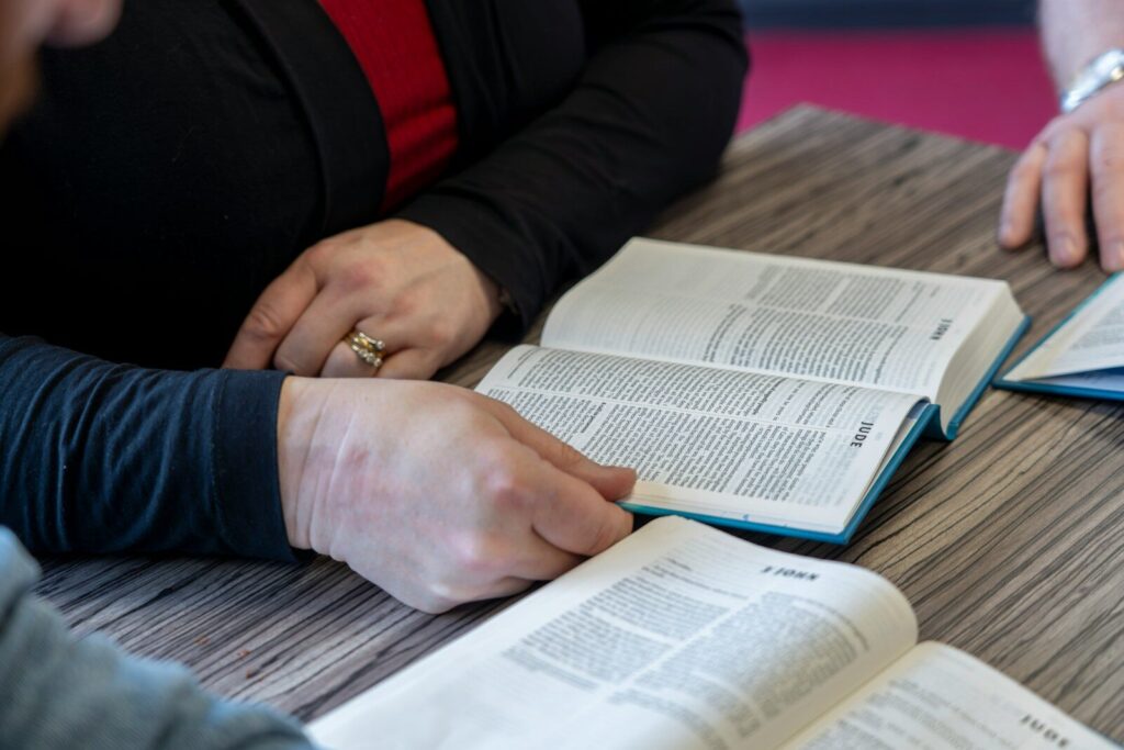 two people sitting at a table with open books